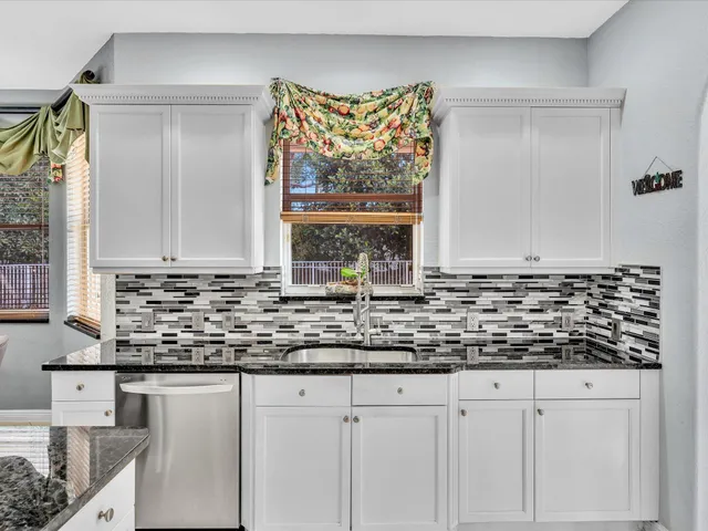 a front view of a house with a garden and trees
