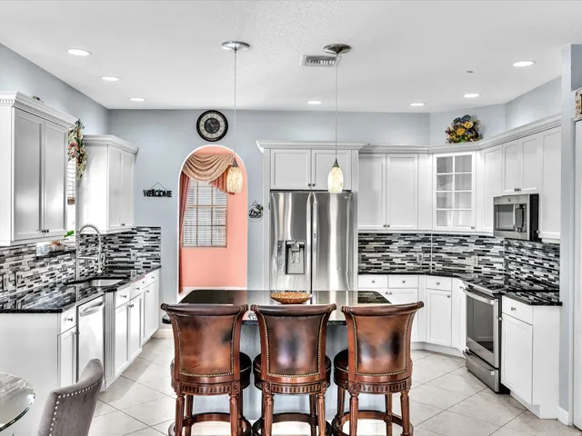 a front view of a house with a yard and potted plants