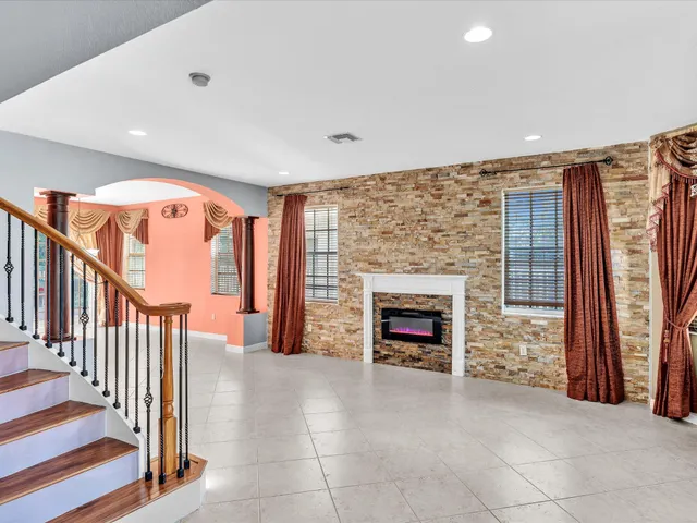 a view of an empty room with wooden floor and windows