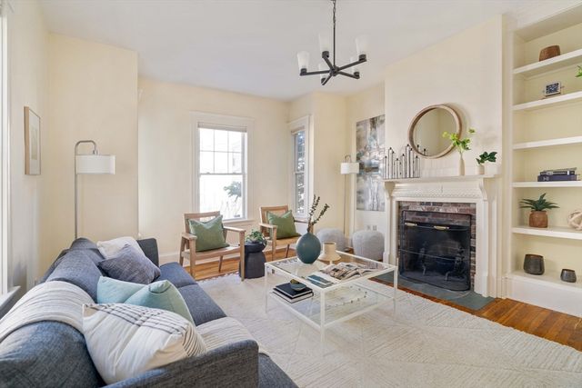 a living room with furniture a fireplace and window