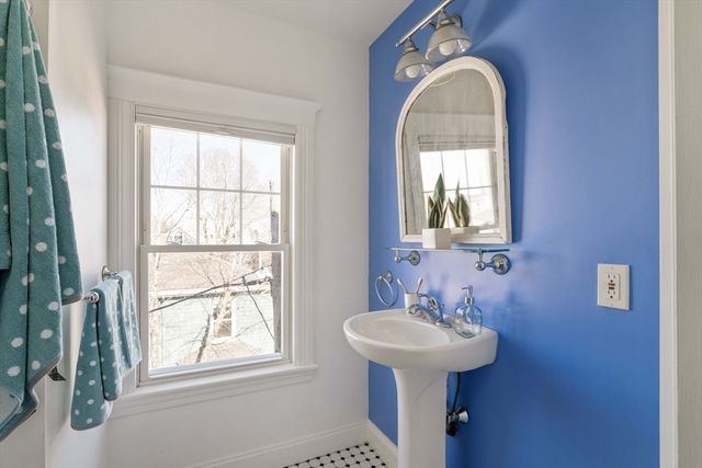 a bathroom with a sink a mirror and a window
