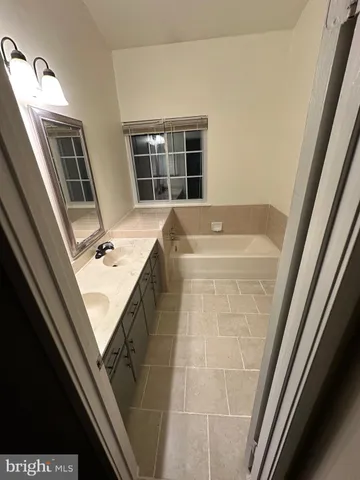 a bathroom with a bathtub sink and window