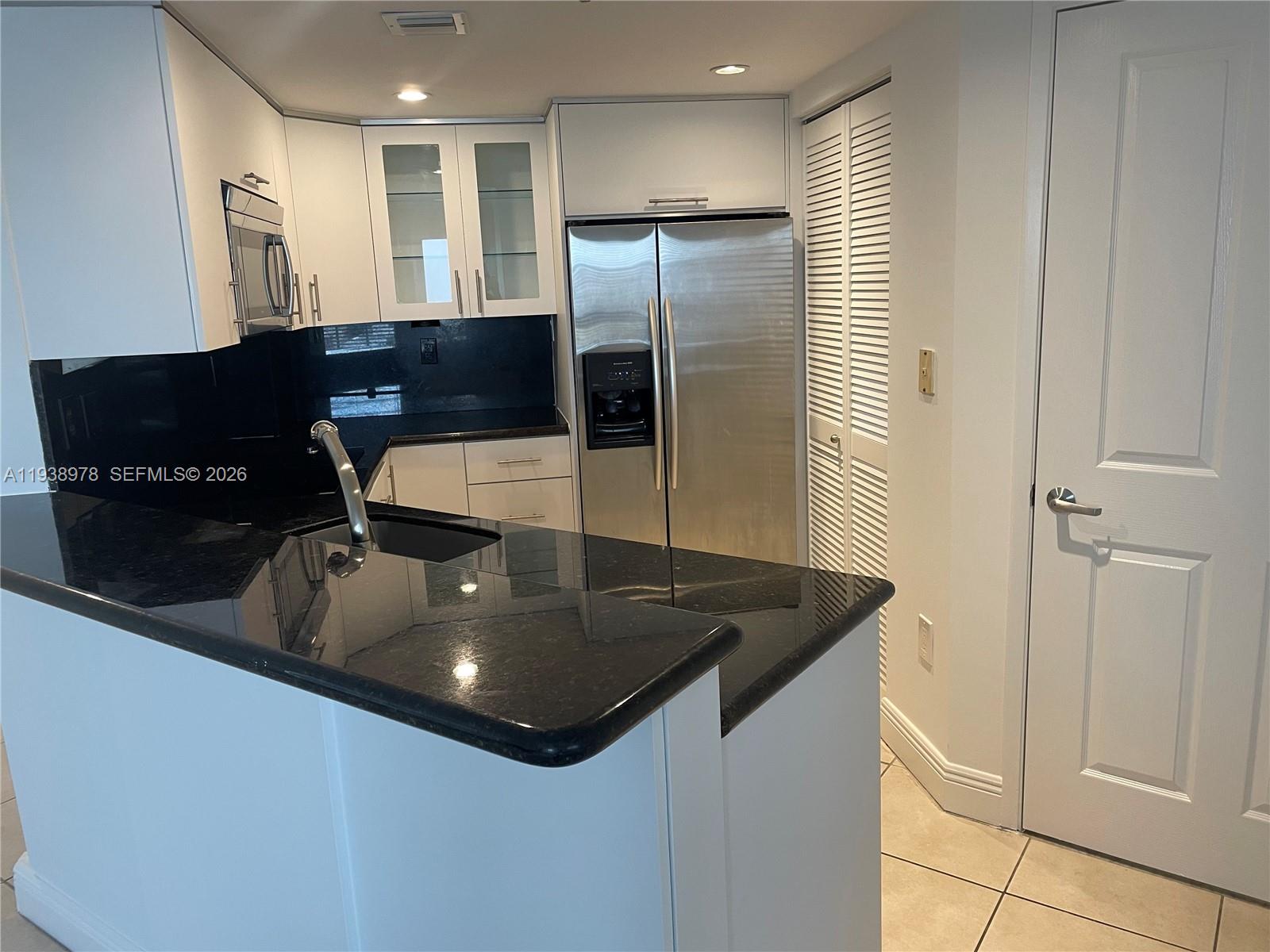2351 Douglas Road, Unit 809 Miami, FL 33145 - Photo 8 of 14 a kitchen with stainless steel appliances granite countertop a sink and a refrigerator