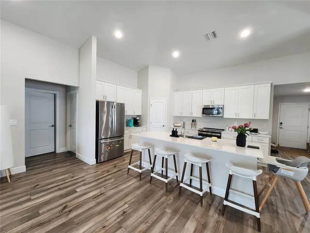 a kitchen with white cabinets and stainless steel appliances