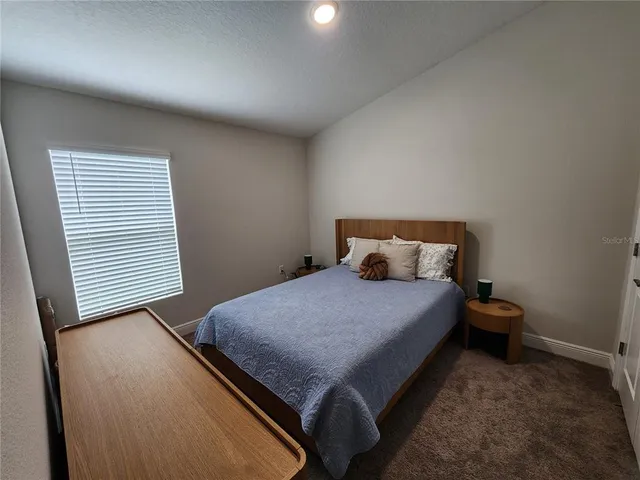 a bed sitting in a bedroom next to a window