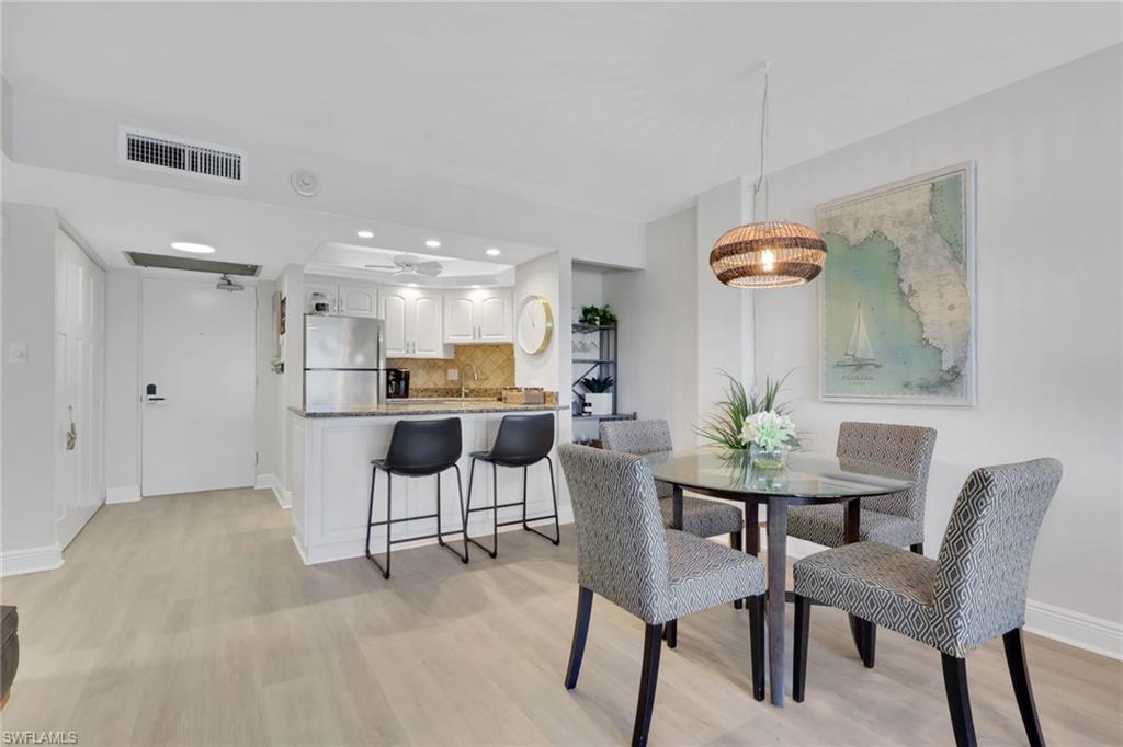 1 Bluebill Avenue, Unit 401 Naples, FL 34108 - Photo 13 of 35 a view of a dining room with furniture and wooden floor