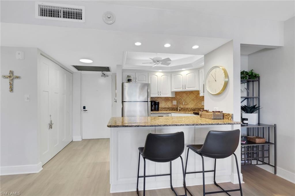 1 Bluebill Avenue, Unit 401 Naples, FL 34108 - Photo 15 of 35 a large kitchen with a table and chairs
