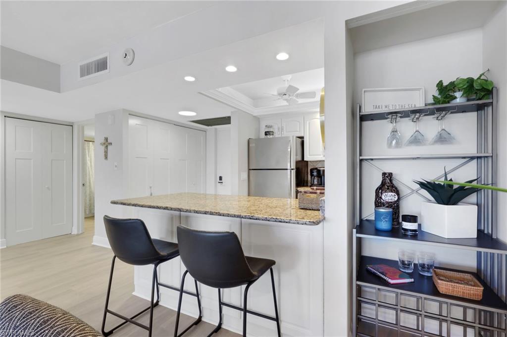 1 Bluebill Avenue, Unit 401 Naples, FL 34108 - Photo 16 of 35 a kitchen with a table and chairs