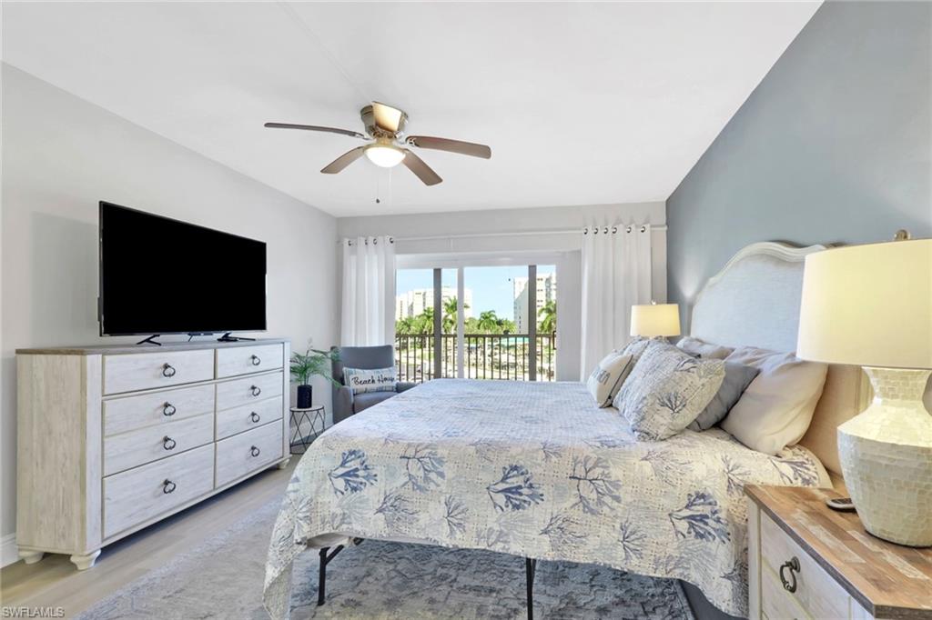 1 Bluebill Avenue, Unit 401 Naples, FL 34108 - Photo 18 of 35 a bedroom with a bed and a flat screen tv on dresser