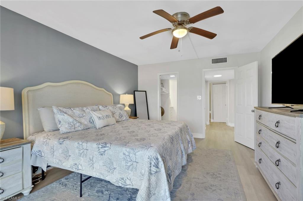 1 Bluebill Avenue, Unit 401 Naples, FL 34108 - Photo 20 of 35 a spacious bedroom with a bed and a flat screen tv