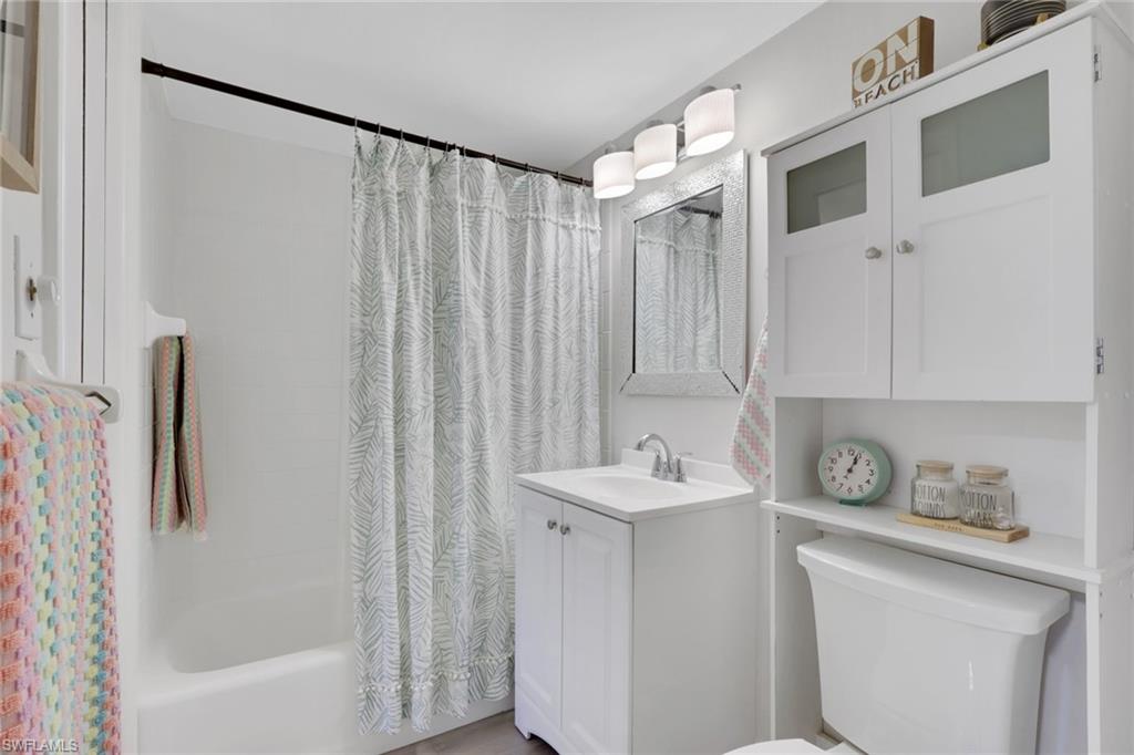 1 Bluebill Avenue, Unit 401 Naples, FL 34108 - Photo 21 of 35 a bathroom with a sink a mirror and a shower