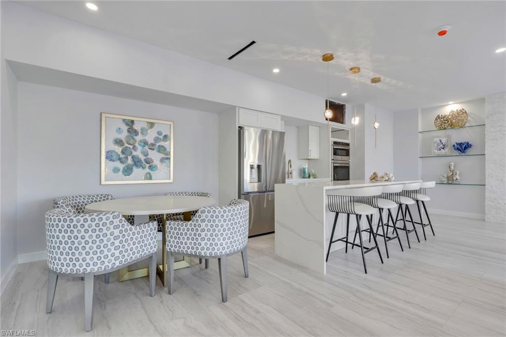 1 Bluebill Avenue, Unit 401 Naples, FL 34108 - Photo 32 of 35 a dining room with furniture and wooden floor