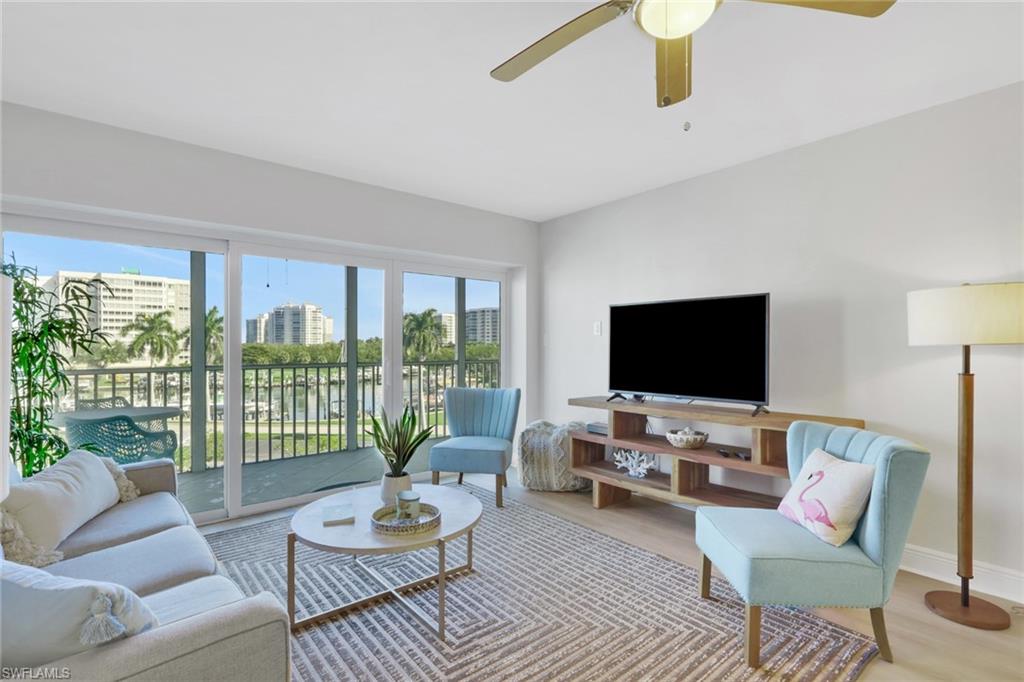 1 Bluebill Avenue, Unit 401 Naples, FL 34108 - Photo 10 of 35 a living room with furniture and a flat screen tv