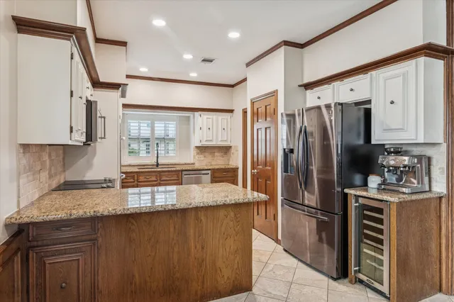a kitchen with stainless steel appliances granite countertop a refrigerator a sink and a stove