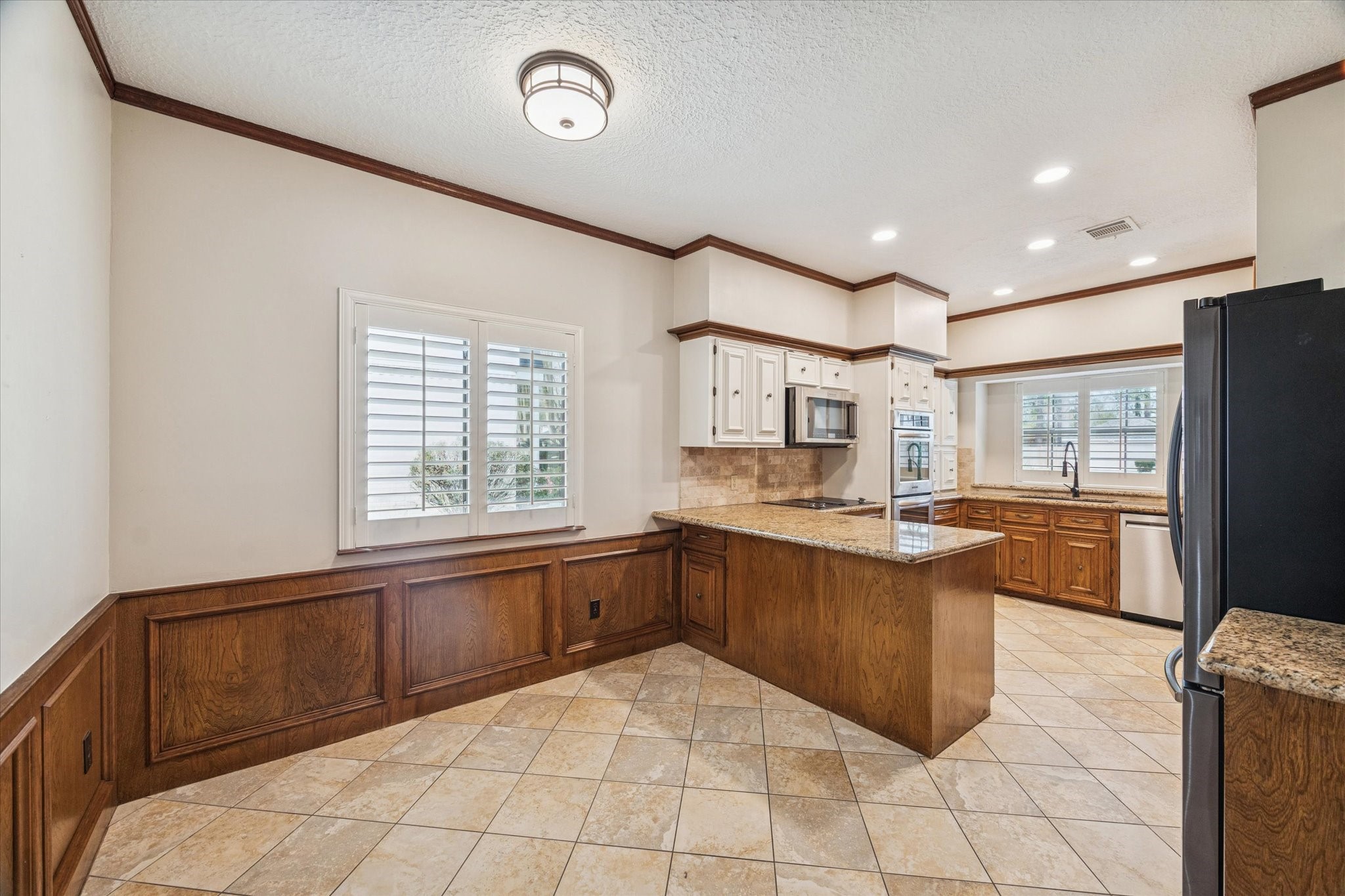 18327 Forest Elms Drive Spring, TX 77388 - Photo 12 of 30 a large kitchen with kitchen island granite countertop a stove a sink a dining table and chair