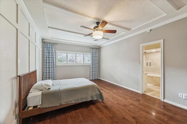 a bedroom with a large bed and wooden floor
