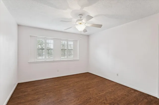 an empty room with a window and a ceiling fan