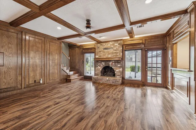 a view of empty room with wooden floor fireplace and windows