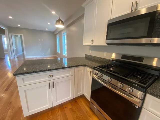 a kitchen with granite countertop a stove and a microwave