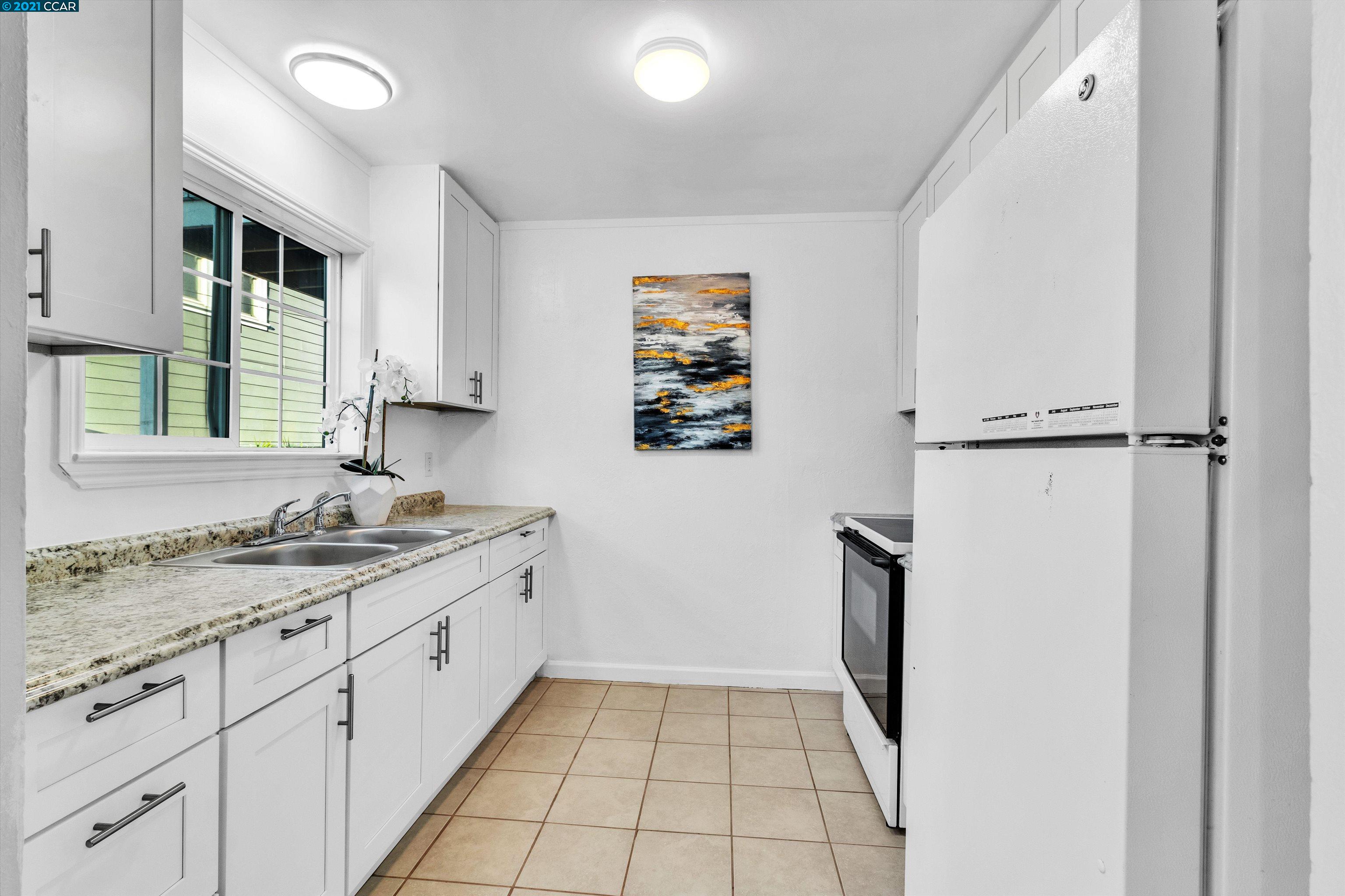 Herbert Guice Way Oakland, CA 94621 - Photo 8 of 40 a kitchen with a sink a refrigerator and cabinets