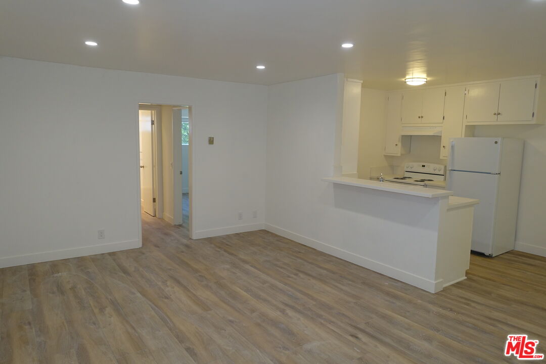 a view of a kitchen with a sink and wooden floor
