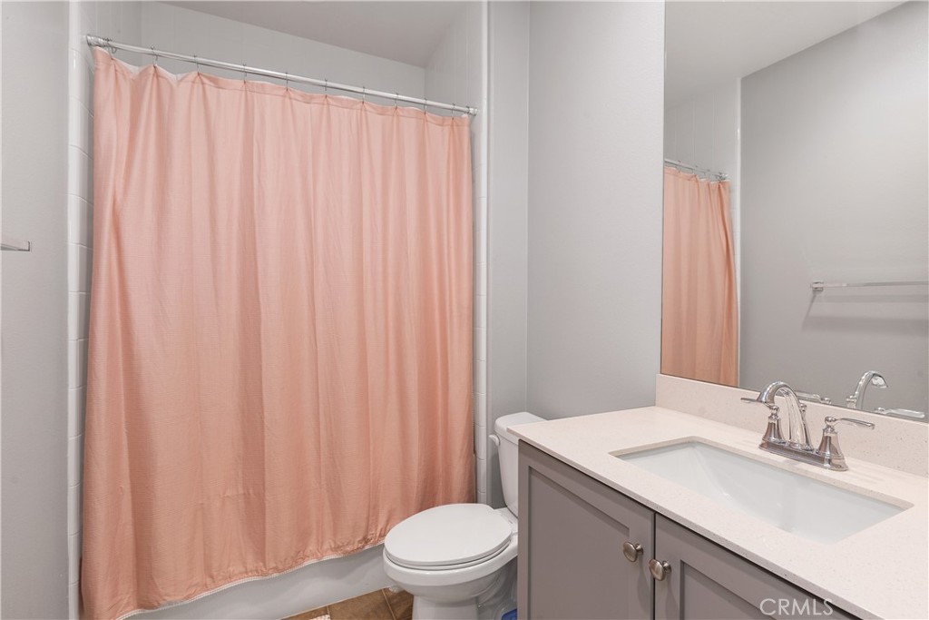 31329 Via Nubes Temecula, CA 92592 - Photo 4 of 45 a bathroom with a sink a toilet and shower curtain