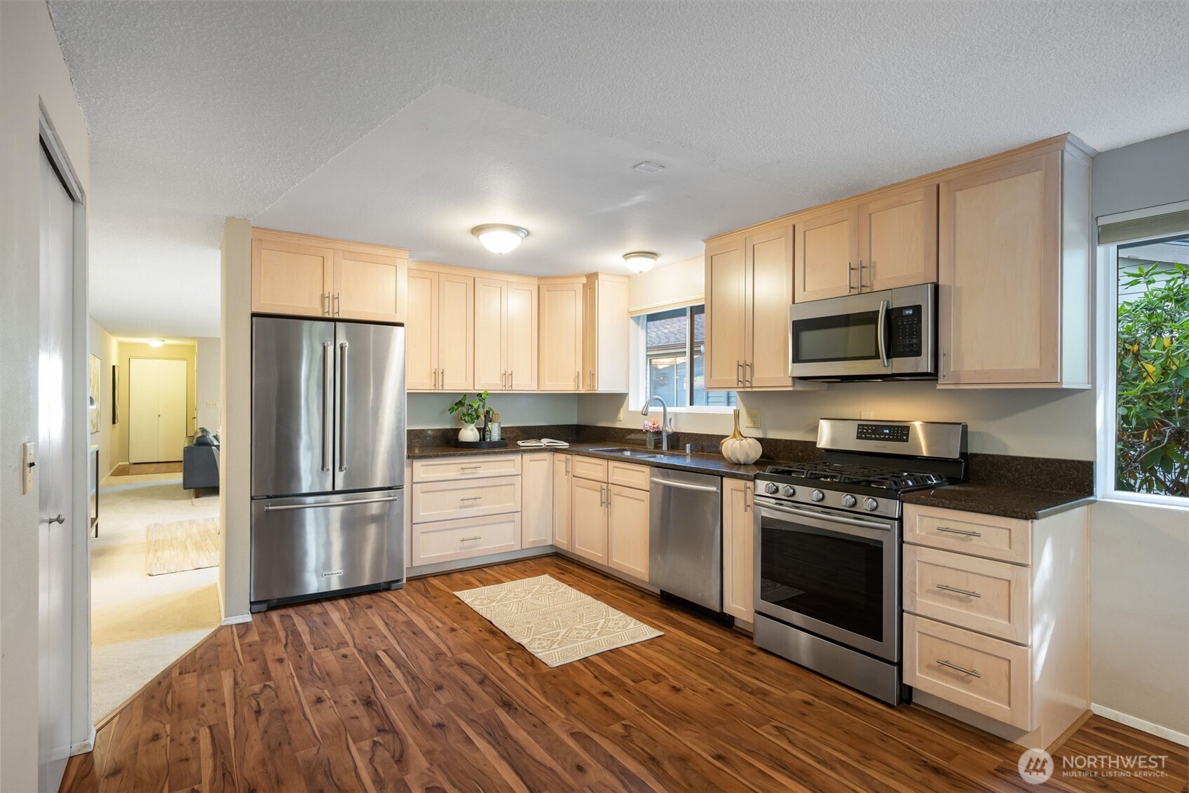 24431 11th Avenue South Des Moines, WA 98198 - Photo 11 of 39 a kitchen with granite countertop a refrigerator stove and microwave