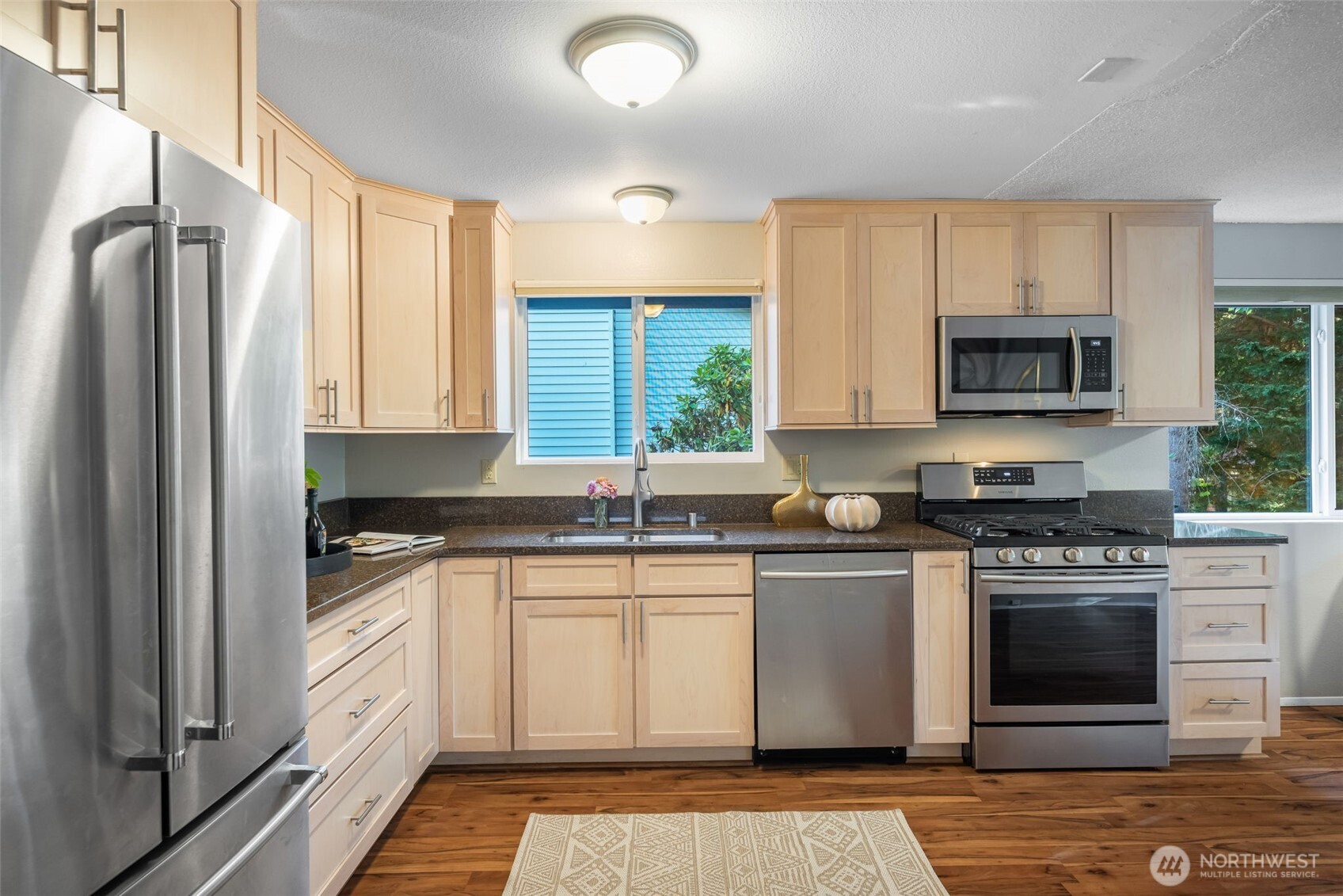 24431 11th Avenue South Des Moines, WA 98198 - Photo 12 of 39 a kitchen with stainless steel appliances granite countertop a stove a sink and a microwave
