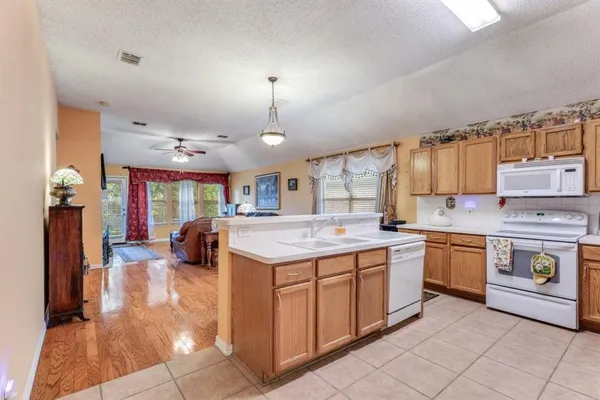 a kitchen with a stove sink and cabinets