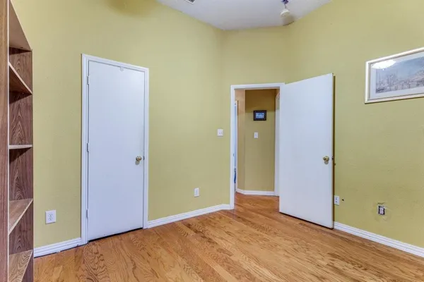 a view of an empty room with wooden floor