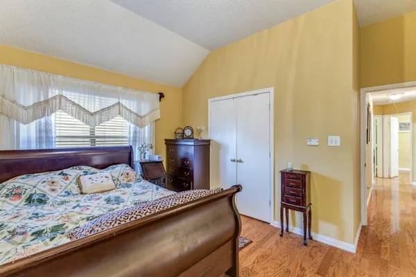 a bedroom with a bed and wooden floor