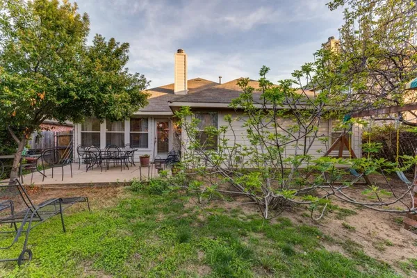 a view of a house with patio next to a yard