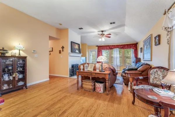a living room with furniture a piano and a large window