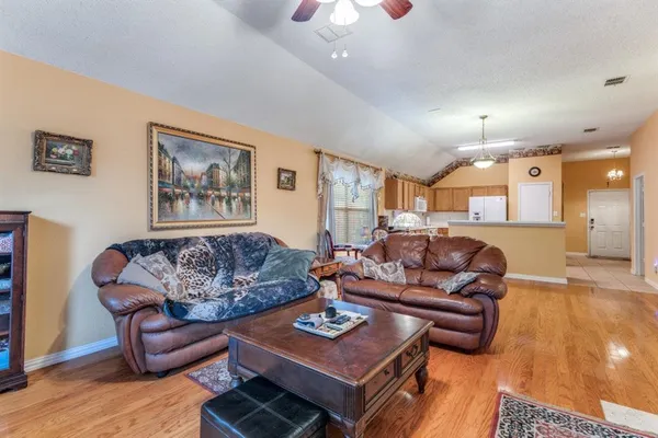 a living room with furniture and a wooden floor