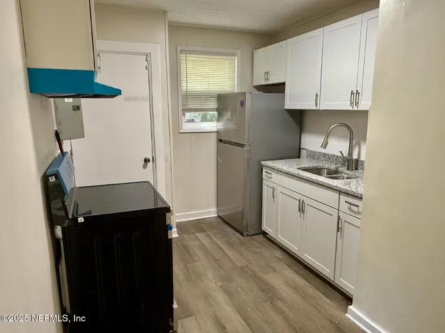 a kitchen with stainless steel appliances a refrigerator sink and cabinets