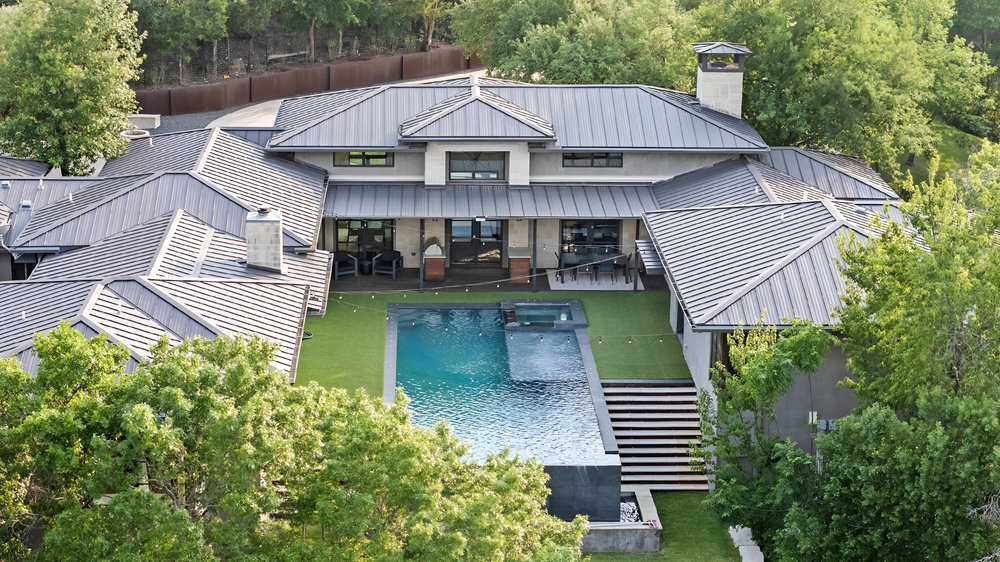 1905 Paisano Road Austin, TX 78746 - Photo 34 of 40 An aerial perspective reveals a private oasis, blending modern architecture with lush natural surroundings and a refreshing pool.