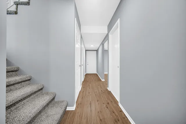 a view of a hallway with wooden floor and staircase