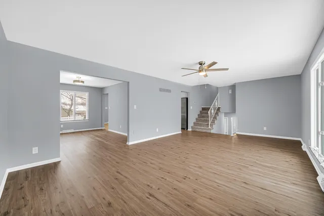 a view of a livingroom with wooden floor and a ceiling fan