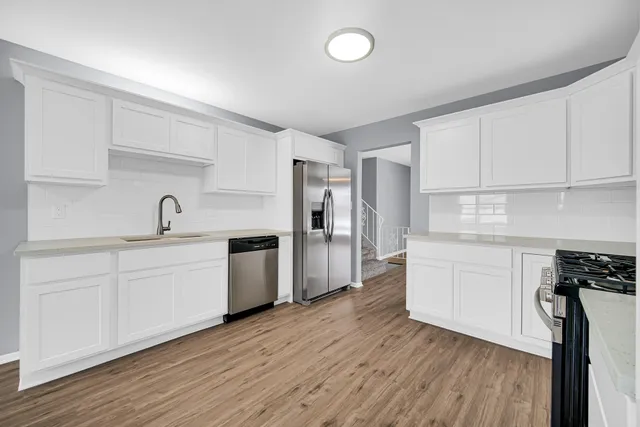 a kitchen with sink cabinets and wooden floor