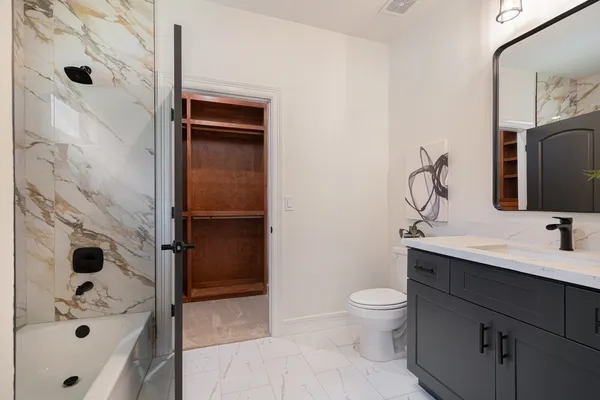 a bathroom with a sink a toilet and shower
