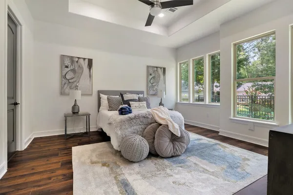 a spacious bedroom with a bed and wooden floor