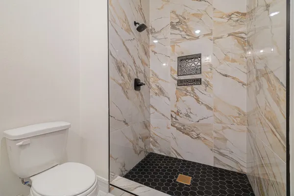 a bathroom with a toilet and a shower