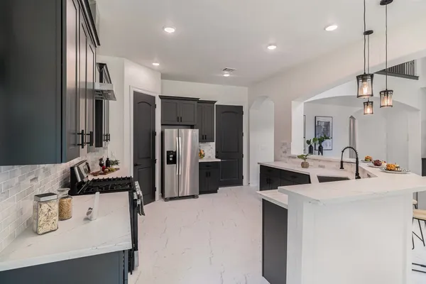 a kitchen with kitchen island a sink appliances and cabinets