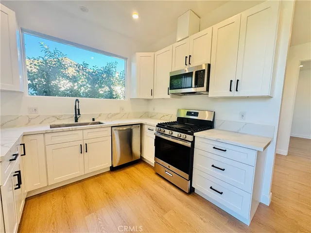 a kitchen with stainless steel appliances a stove a sink and a microwave