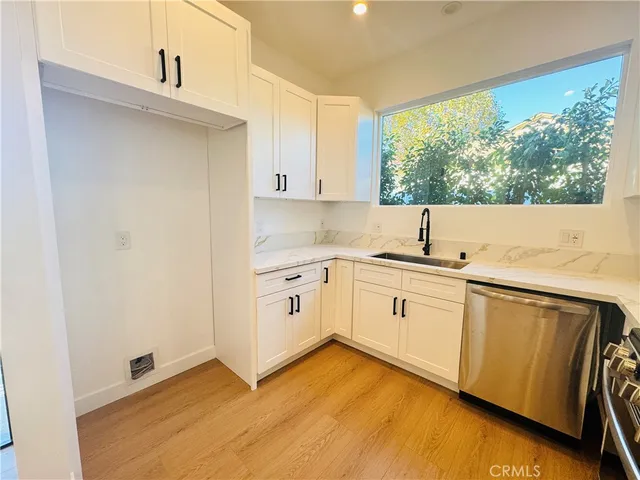 a kitchen with granite countertop white cabinets and white appliances