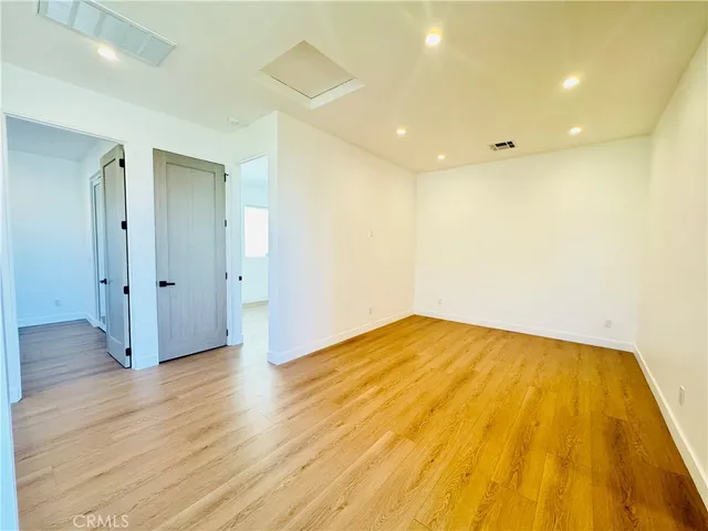 a view of empty room with wooden floor