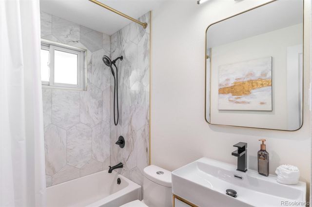 a bathroom with a sink mirror toilet and bathtub