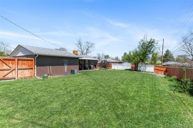 a view of a house with backyard and a tree