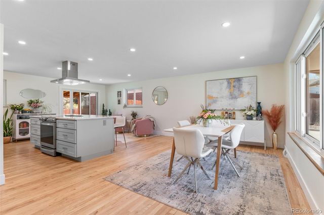 a living room with furniture a wooden floor and kitchen view