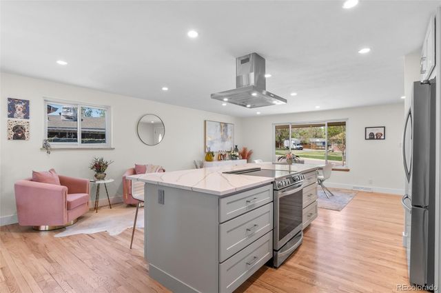 a kitchen with a sink stove and wooden floor